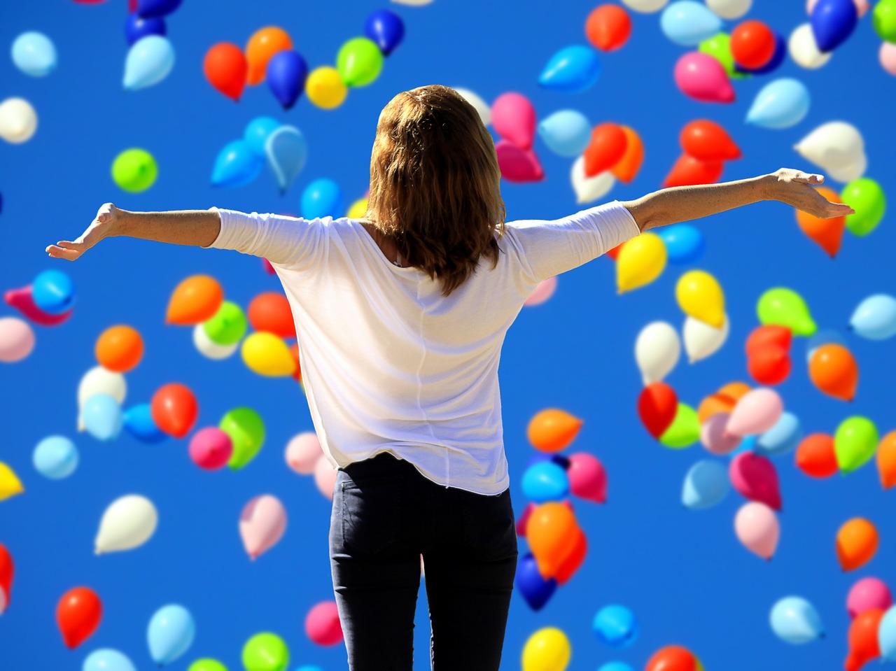 ragazza che trova felicità, equilibrio ed armonia con un cielo di palloncini - mindfulness a Torino, San Salvario