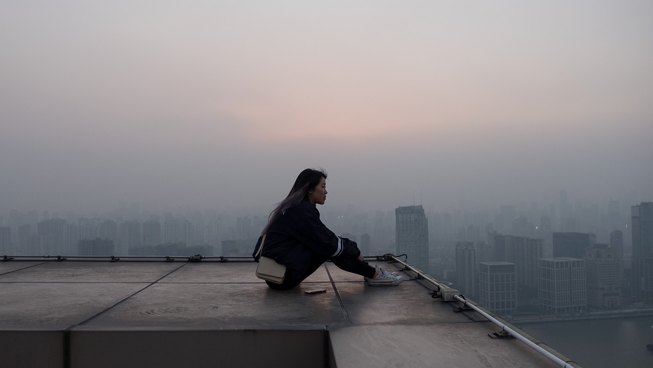ragazza seduta sul tetto di un edificio - sensazione di ansia